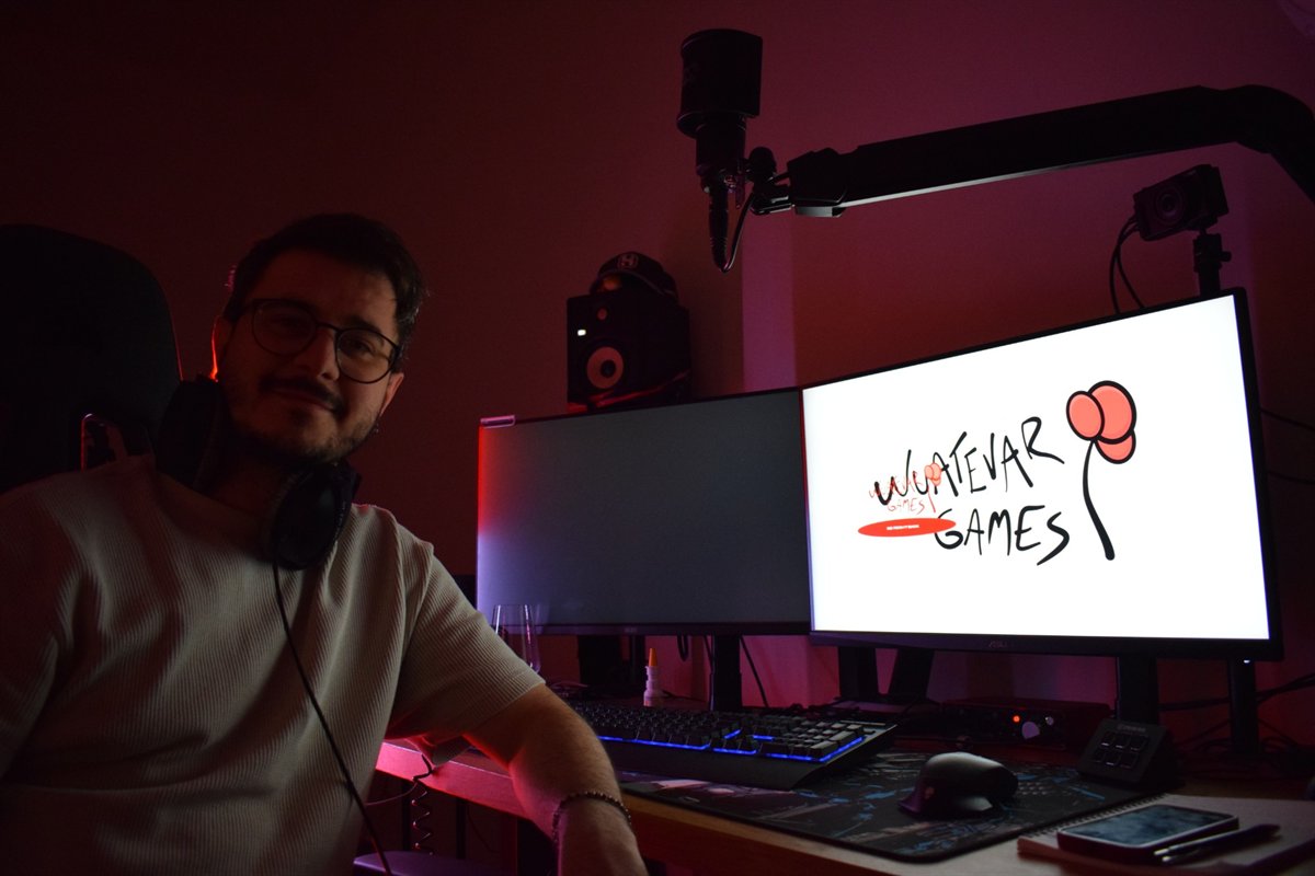 Mehssi, host of Mehssive Indie Night, at the streaming desk with a microphone and the WUATEVAR GAMES logo on screen